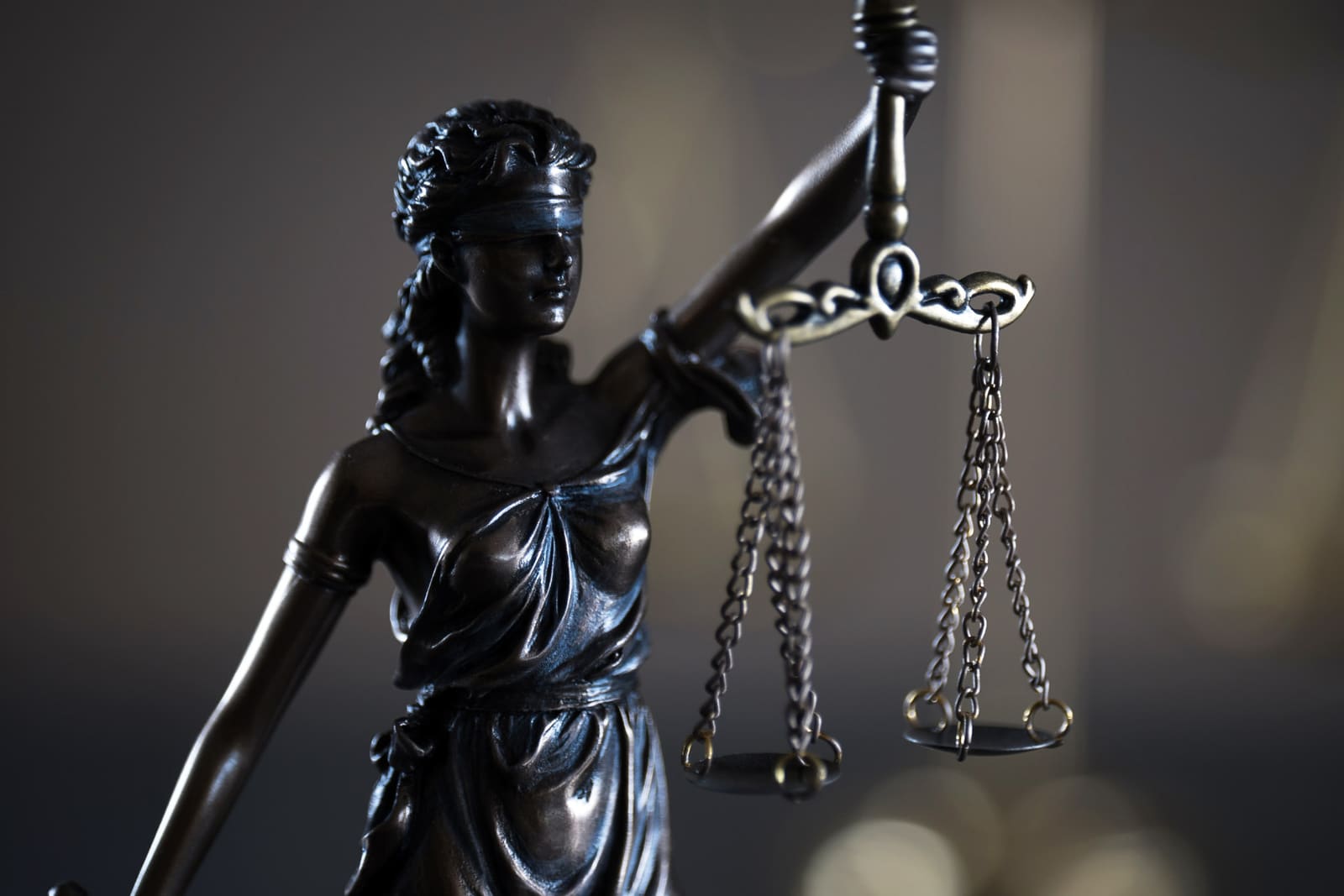 Legal issues for UK independent filmmakers depicted by a black, bronzed statue of a blindfolded woman holding scales of justice