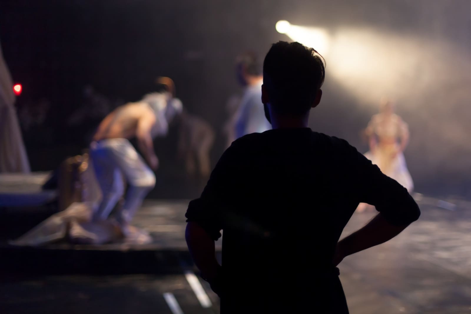 An image showing a silhouetted filmmaker watching as the rest of the cast and crew prepare for action demonstrating the angst of Rejection in UK Independent Filmmaking