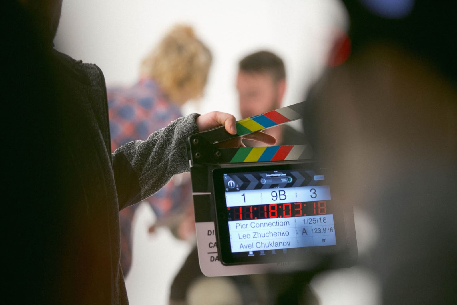 An actor is shown working with a casting director with a digital clapperboard in shot