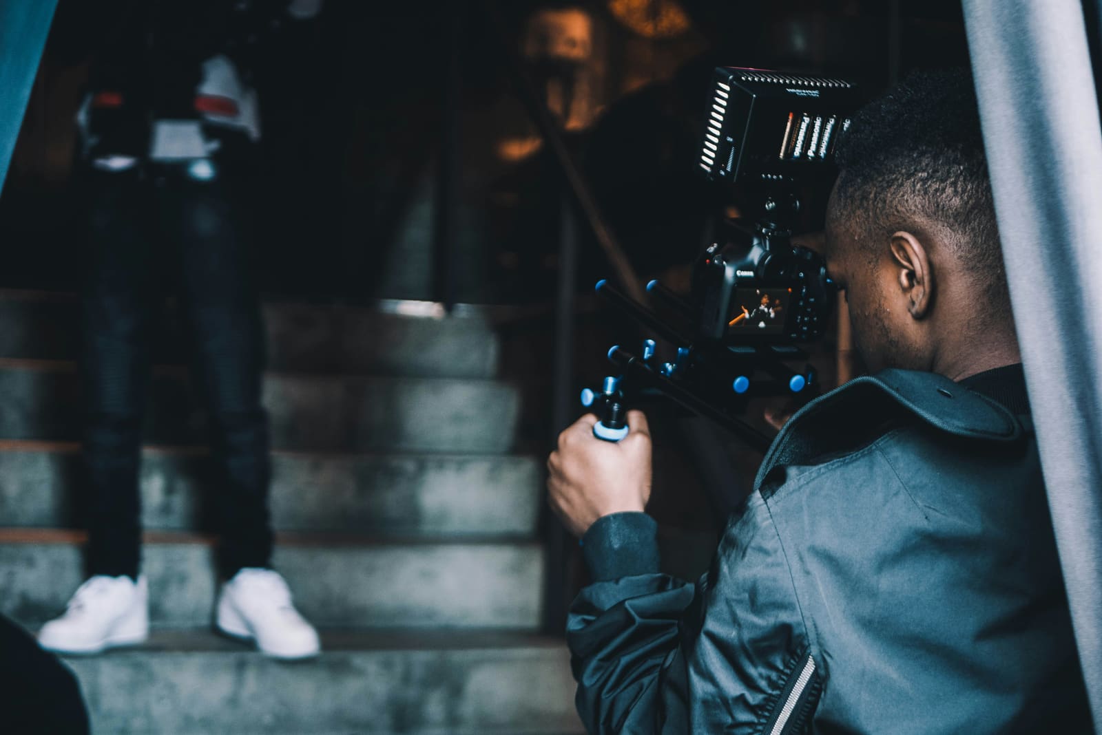 A filmmaker using advanced camera technology and editing software on set.