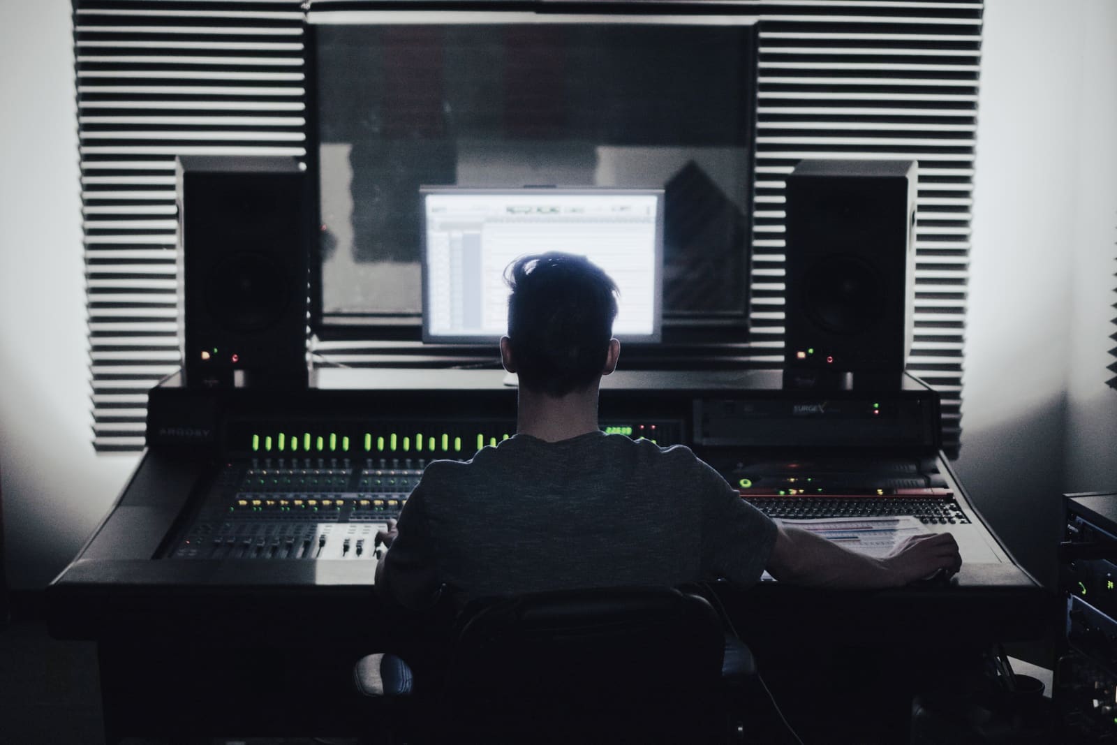 A composer sat at a large expansive music workstation working on Soundscapes in Cinema