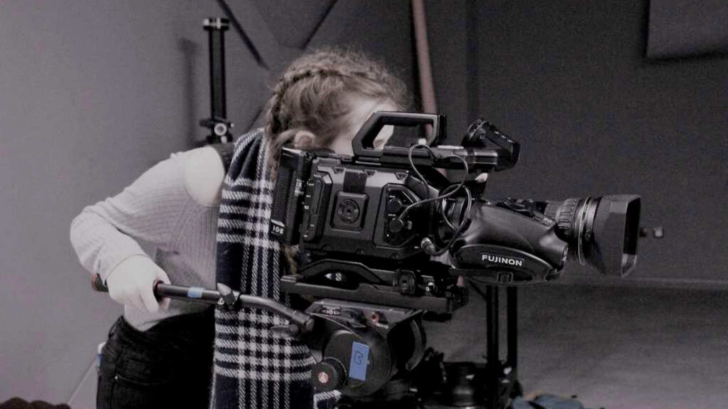 A female filmmaking student working a camera demonstrating Filmmaking in the UK