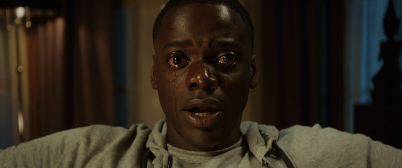 A tense film still from Jordan Peele’s Get Out, capturing the psychological horror and social commentary central to the story.