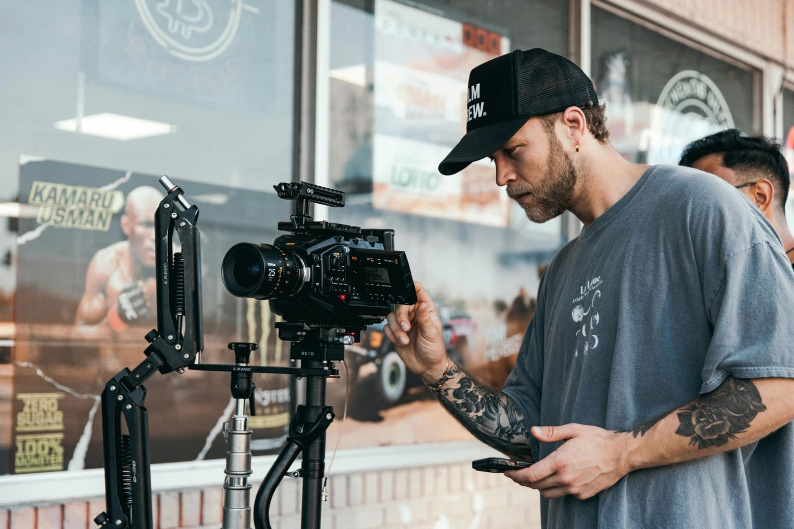 Cinematographer operating a professional camera on a film set with crew and lighting equipment