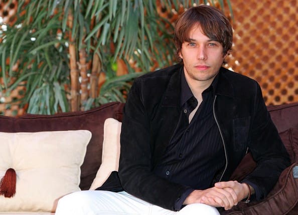 Independent filmmaker working with a small film crew on a city street, reflecting the authentic, character-driven filmmaking style associated with Sean Baker.